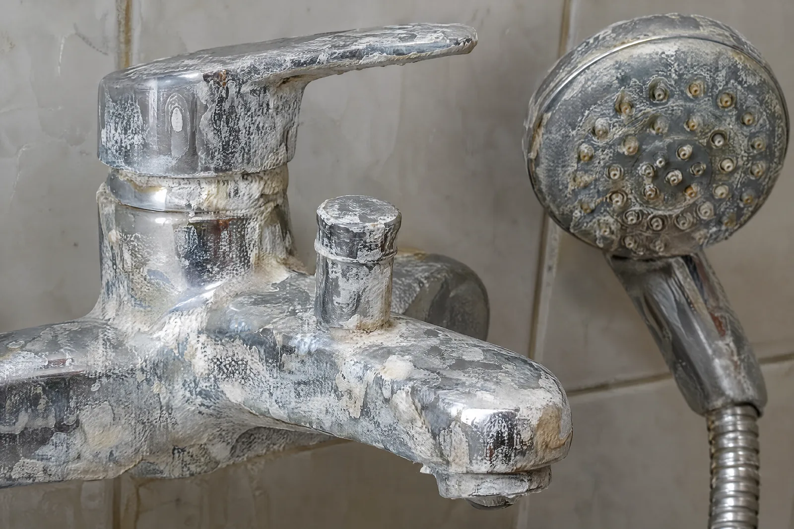 Hard-water limescale crusting a South Florida bathroom faucet