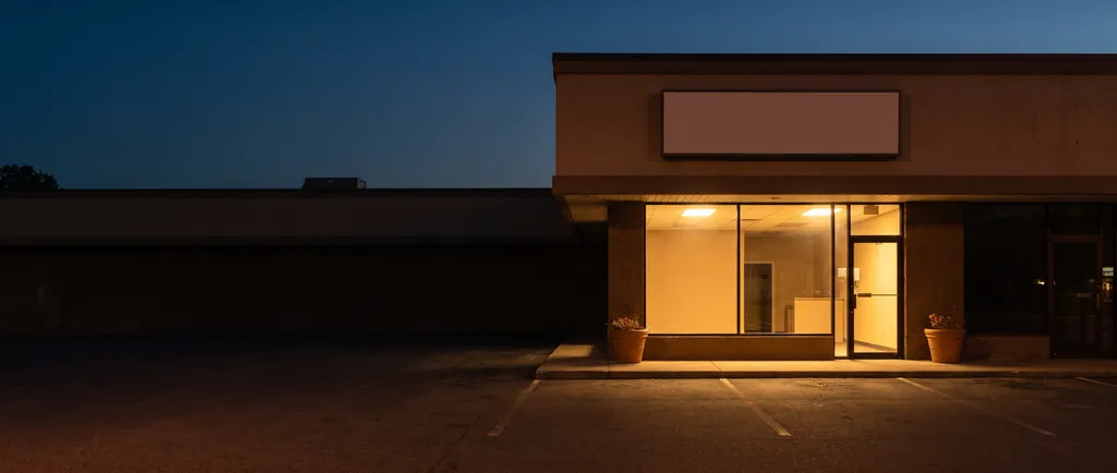 The Flower Shop Dispensary storefront at dusk in North Houston, warm light glowing through the front windows