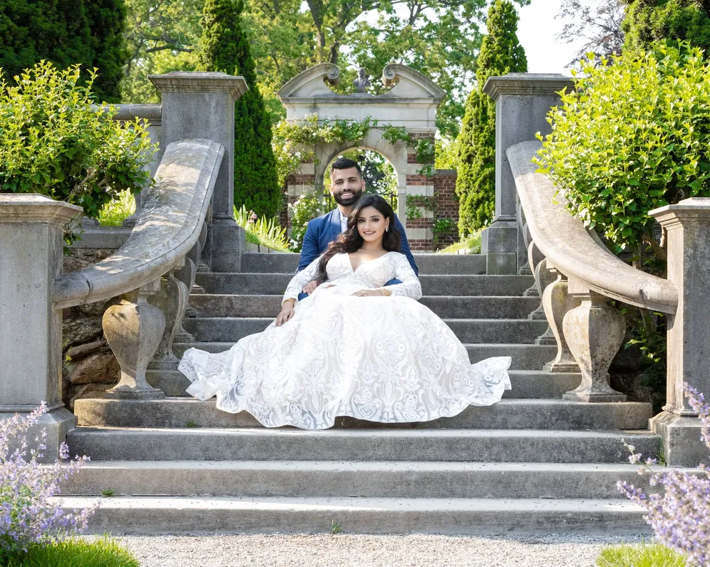 Bride in a white ball gown seated on wide stone steps