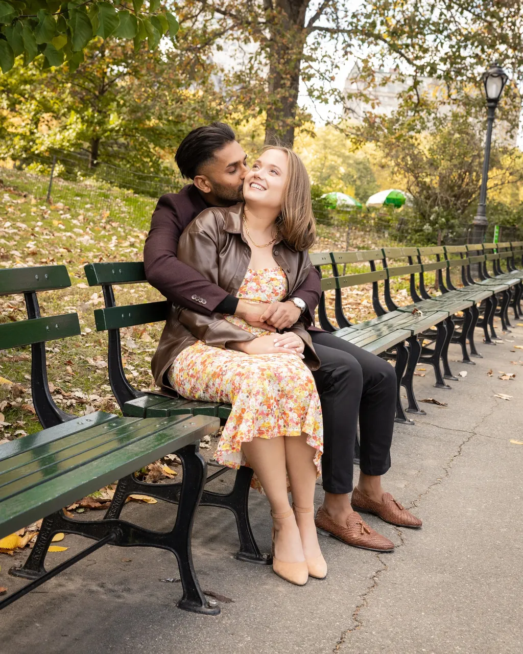 Engaged couple on a park bench in autumn