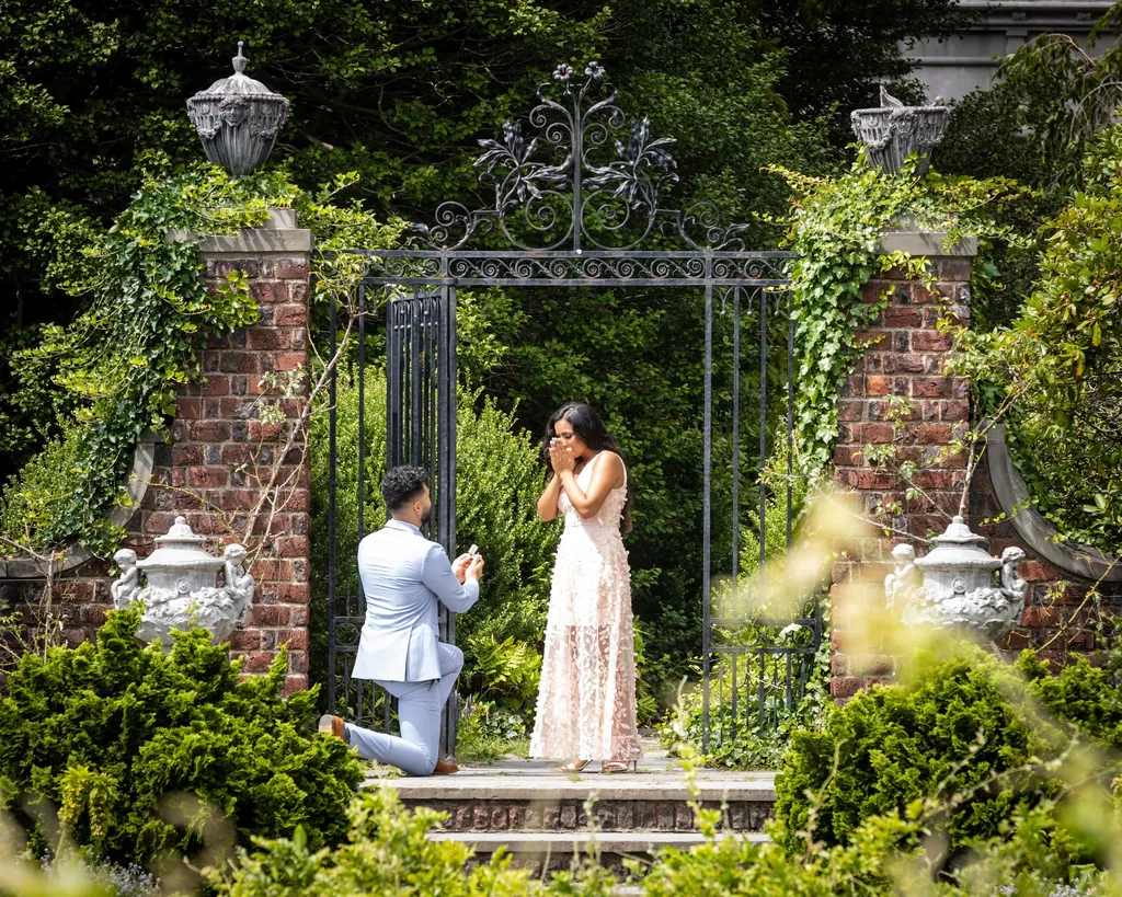 Proposal at a garden gate, he kneels as she turns