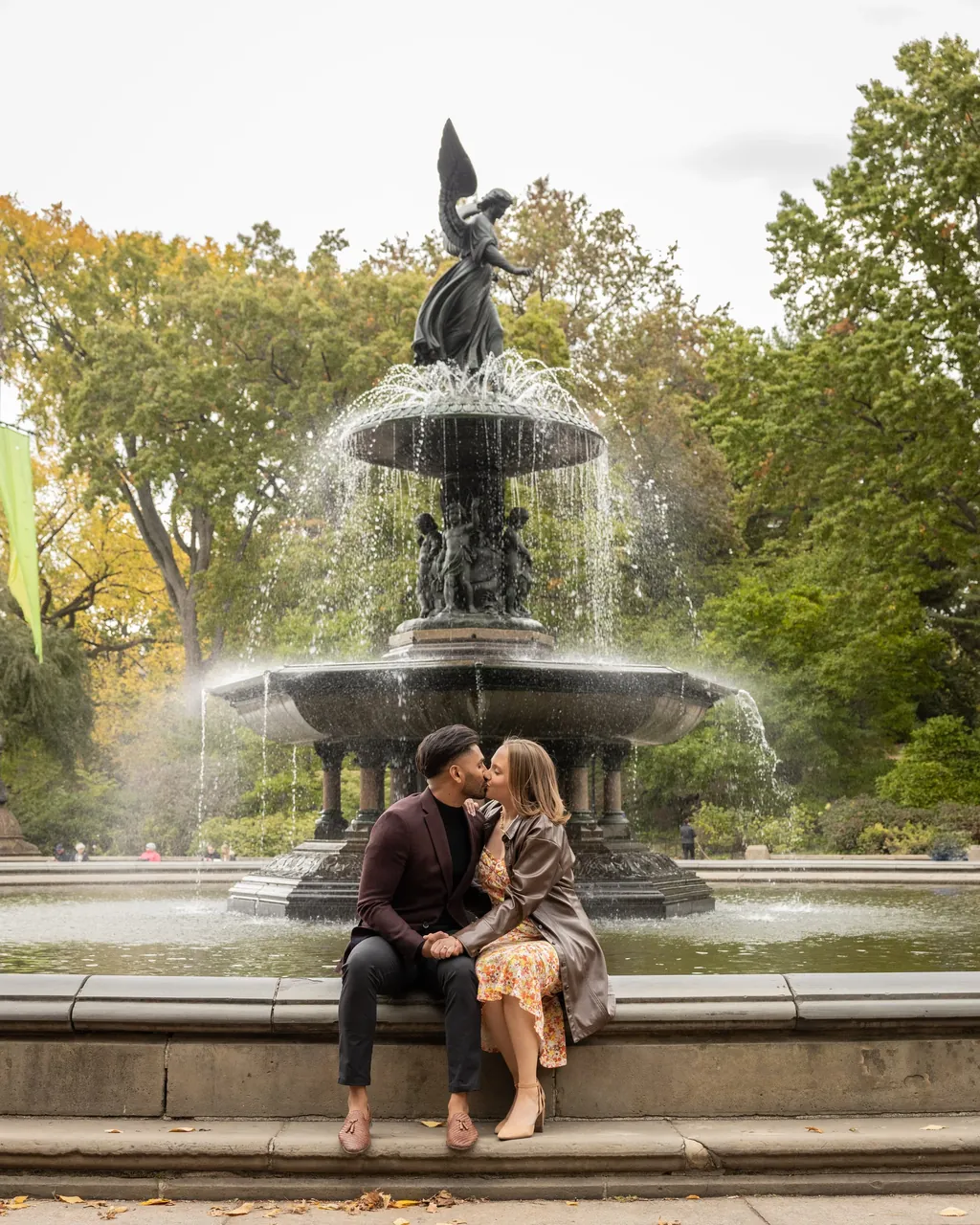 Couple kissing beside a fountain in Central Park