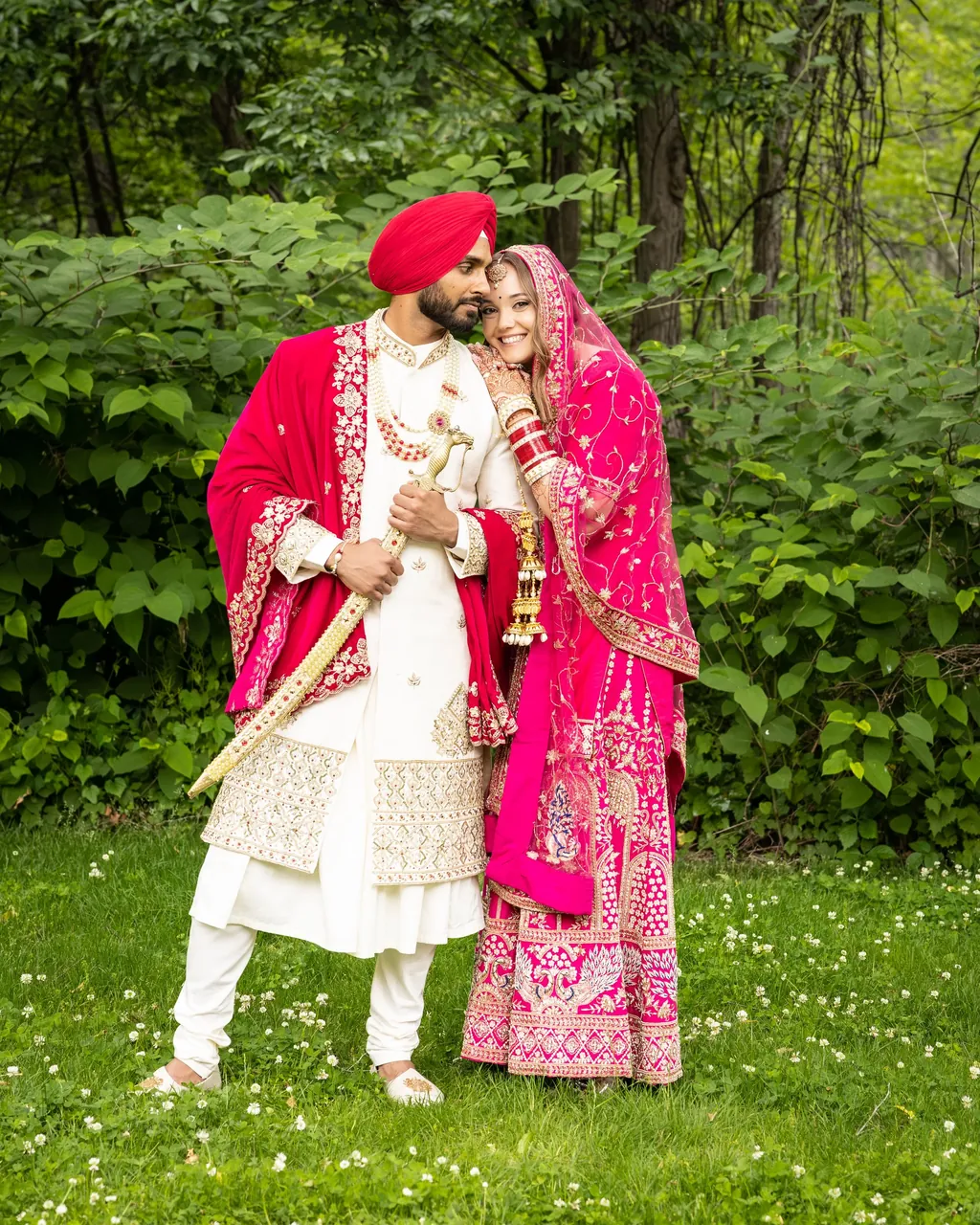 Sikh groom in a red turban with his bride in pink