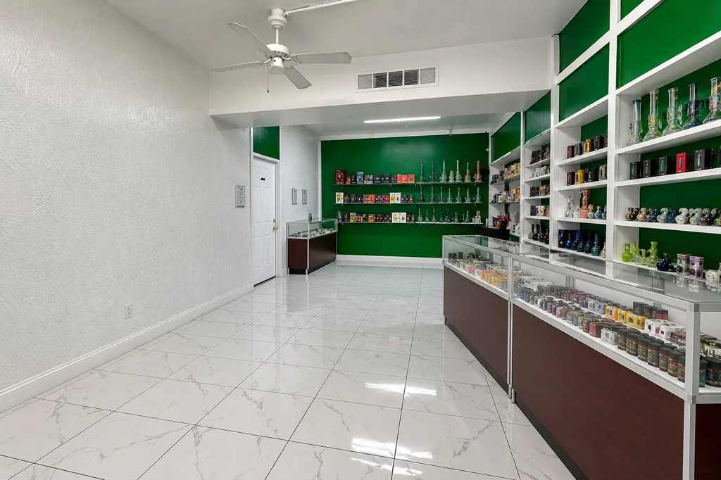 The bright interior of Kush Kingdom with white walls, green shelving and glass cases