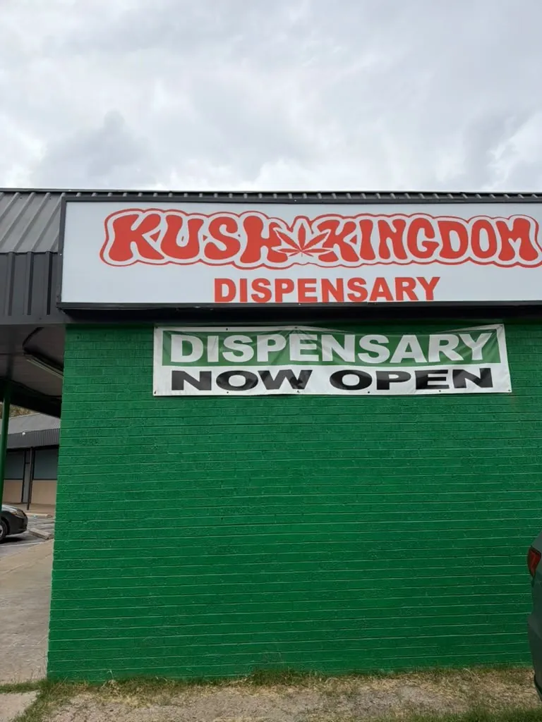 The Kush Kingdom Dispensary sign above the green brick wall