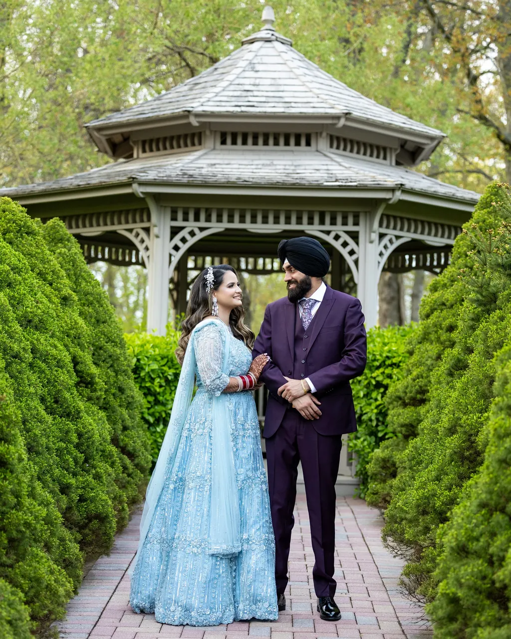 Sikh groom and bride in a pale blue lehenga by a gazebo
