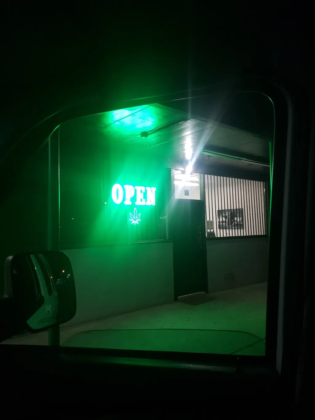Kush Kingdom's OPEN sign glowing at night