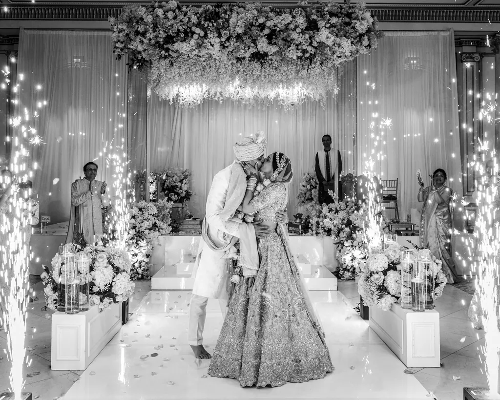 Black and white photo of a bride and groom dancing through a tunnel of sparklers