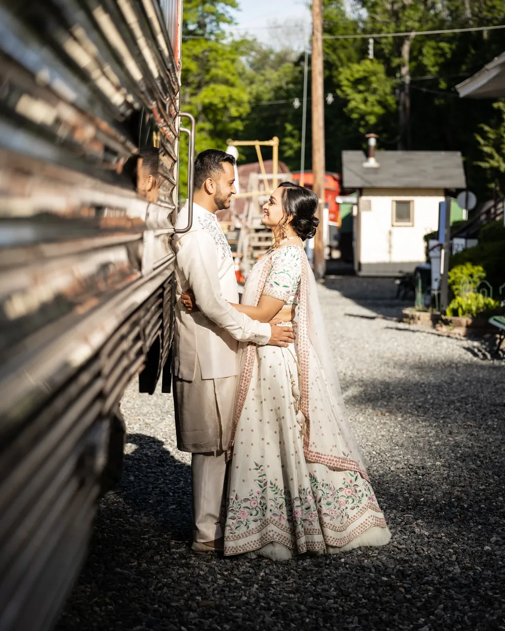 Couple in ivory outfits embracing in a narrow alley