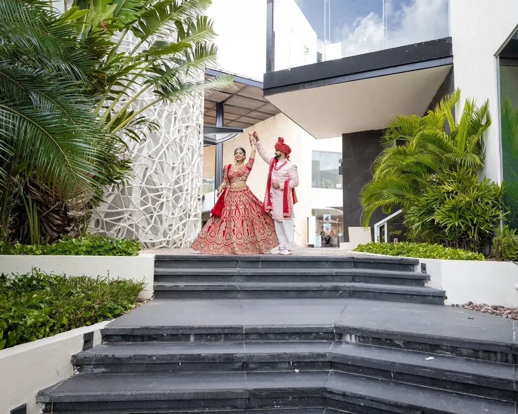Bride descending modern stone steps in a red lehenga