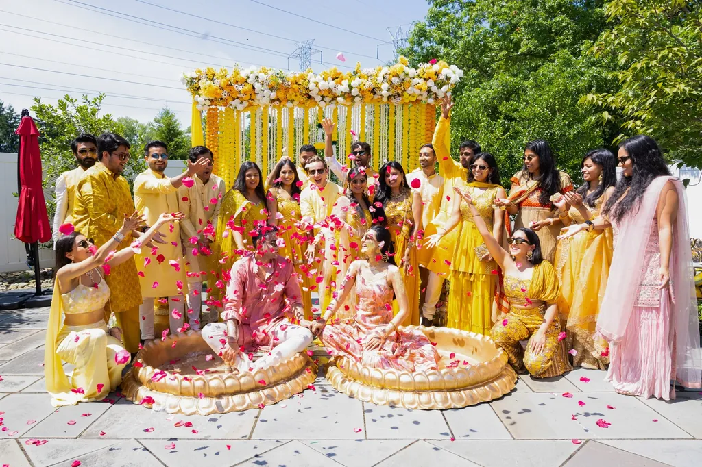 Wedding party in yellow seated under a floral haldi canopy